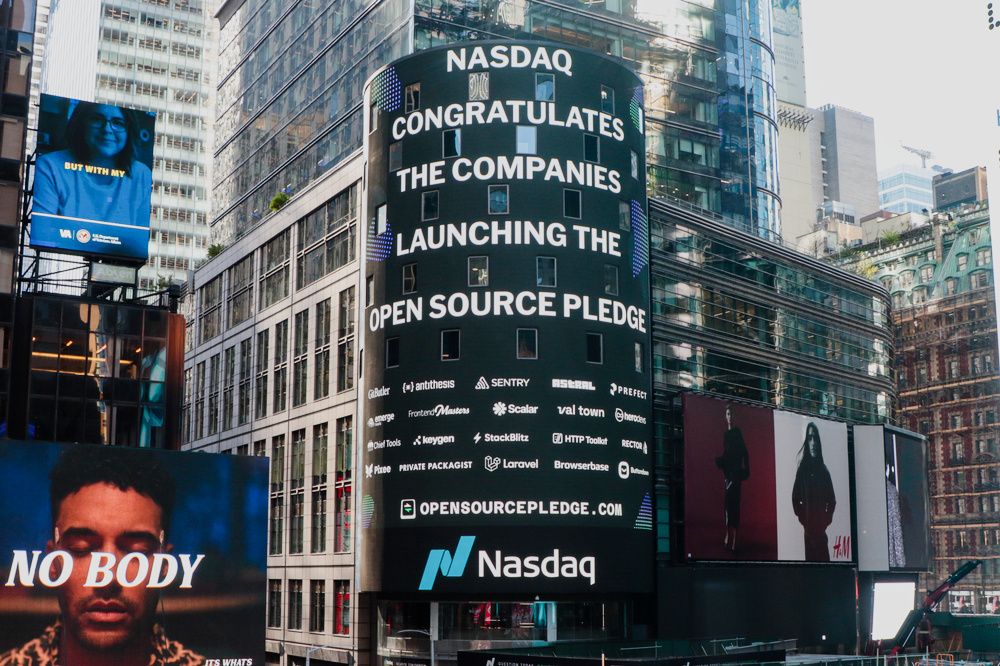 The screen on the Nasdaq tower in Times Square saying “Nasdaq congratulates the companies launching the Open Source Pledge”, followed by many company logos, and a link to https://opensourcepledge.com.