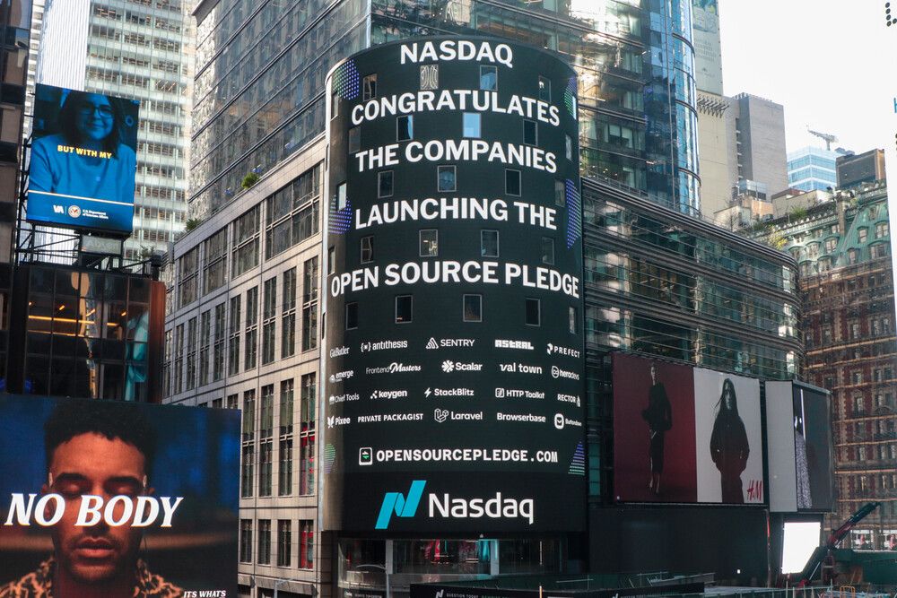 The screen on the Nasdaq tower in Times Square saying “Nasdaq congratulates the companies launching the Open Source Pledge”, followed by many company logos, and a link to https://opensourcepledge.com.