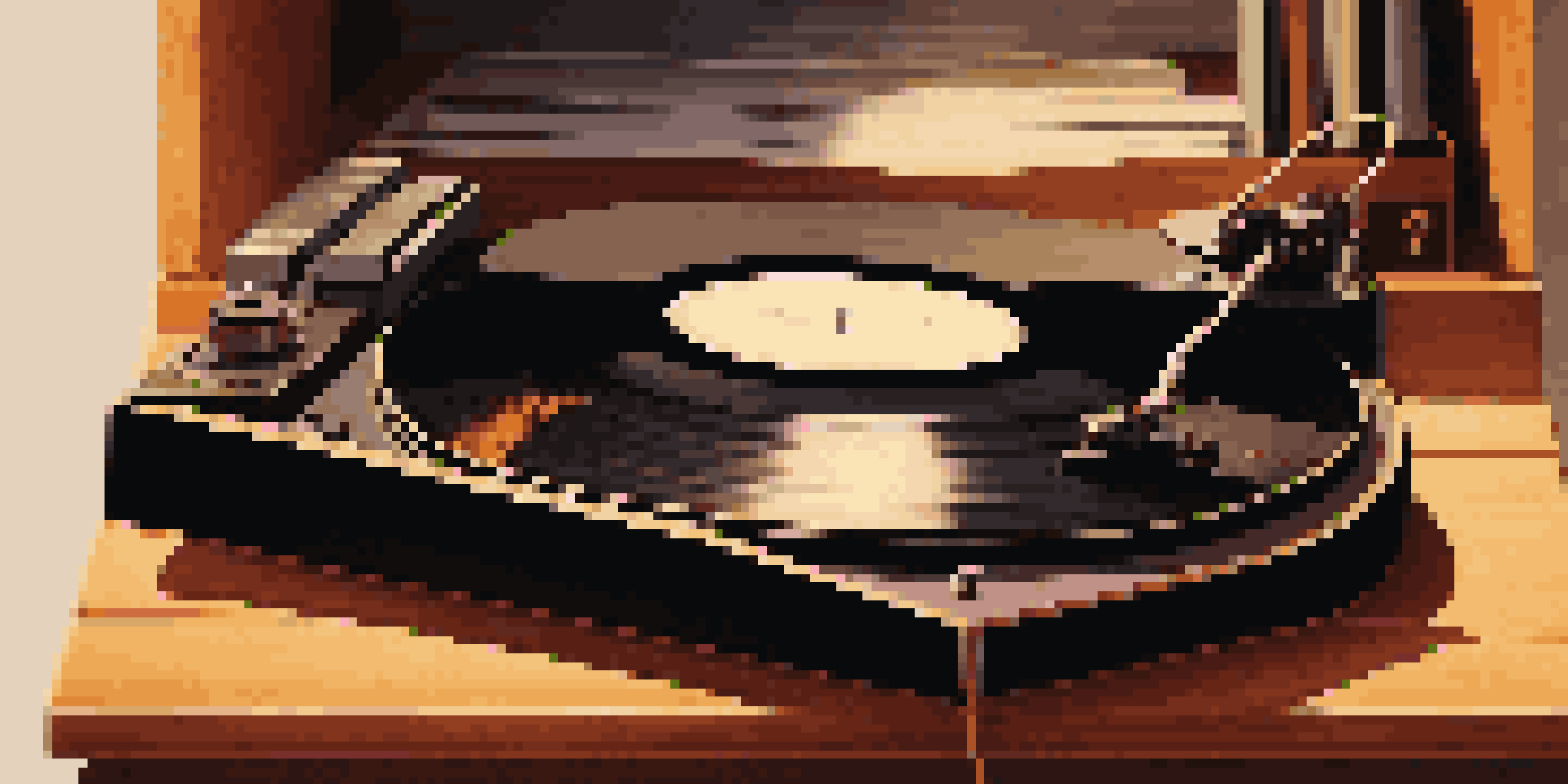 A close-up view of a spinning vinyl record on a turntable, with warm lighting and a wooden shelf in the background.