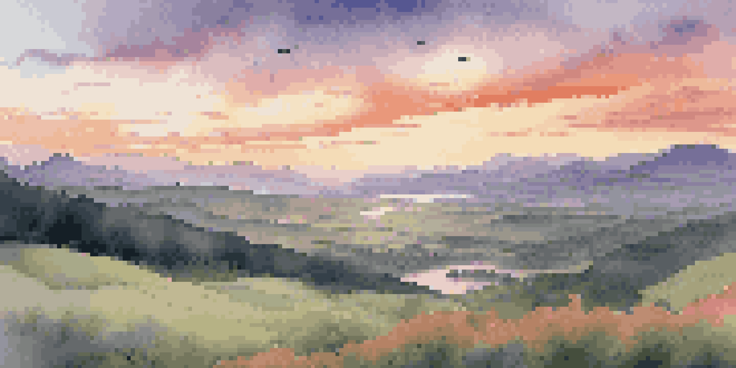 A beautiful sunset over a lush green valley with mountains in the background and a river reflecting the sky's colors.