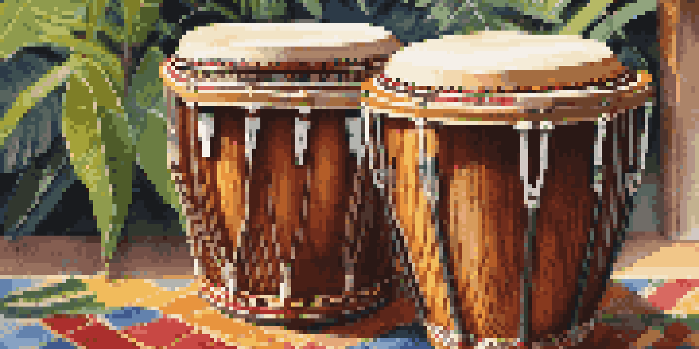 A close-up view of handcrafted bongo drums on a colorful mat surrounded by tropical plants, illuminated by warm sunlight.