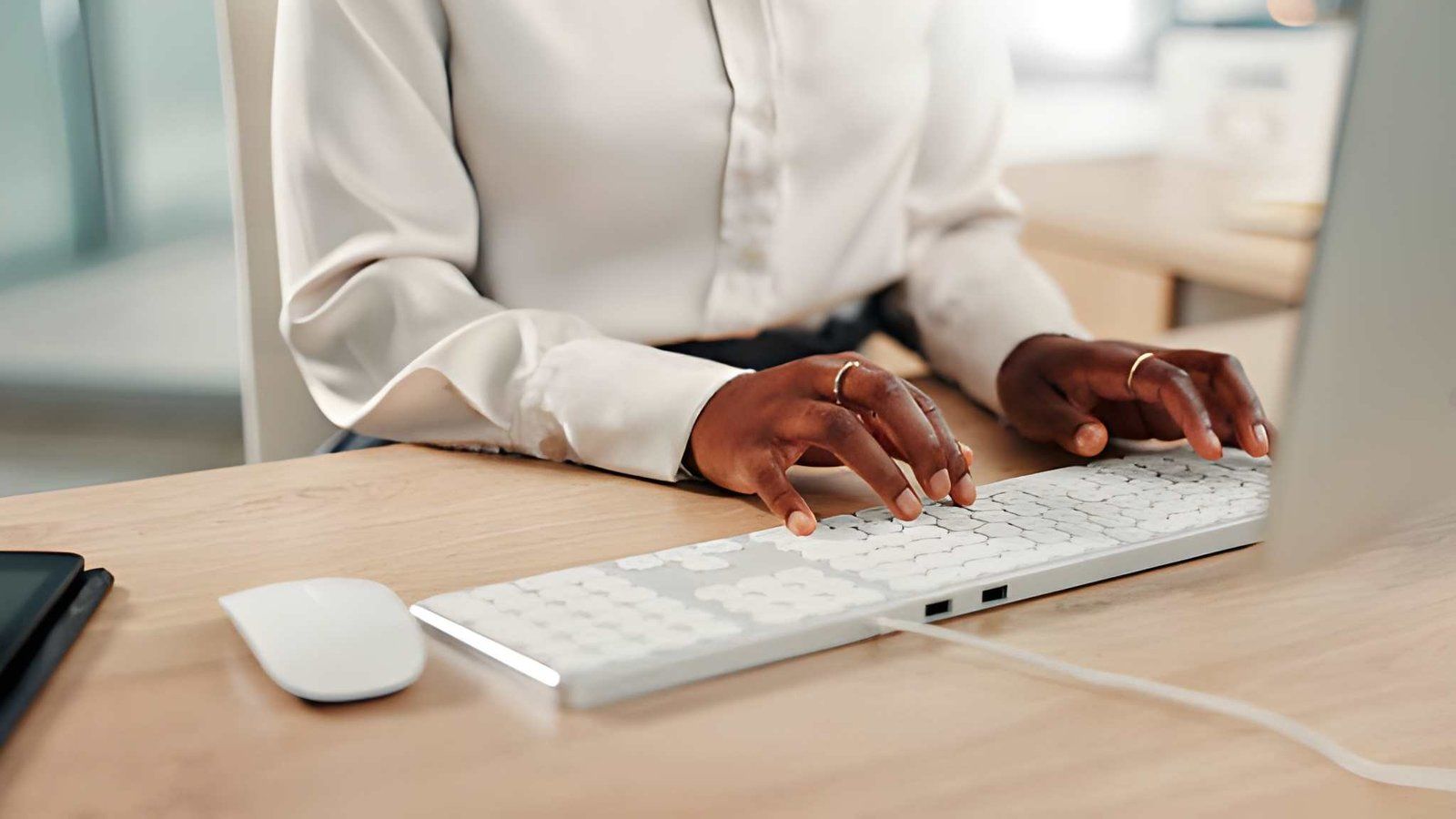 Professional typing on an accessible computer keyboard at an office desk