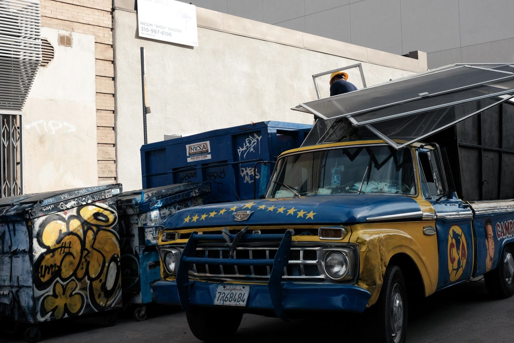 A blue and yellow car with a man