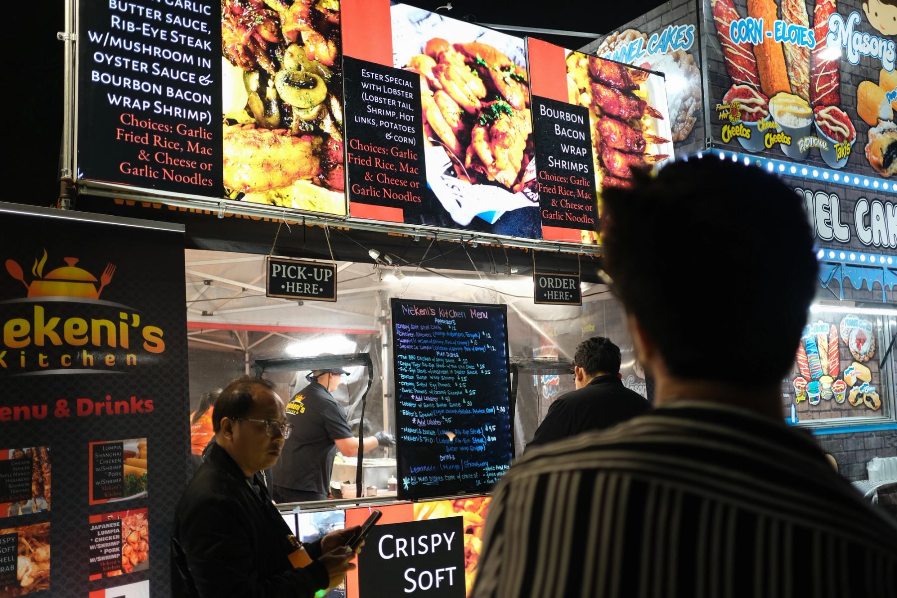 A man looking at a food stand menu