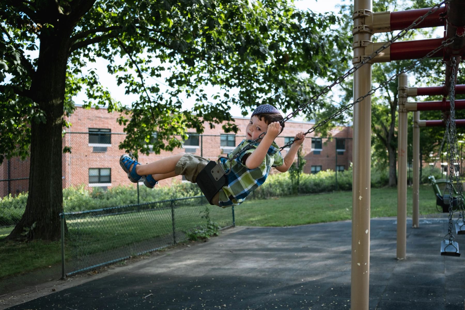 A boy playing on a swing