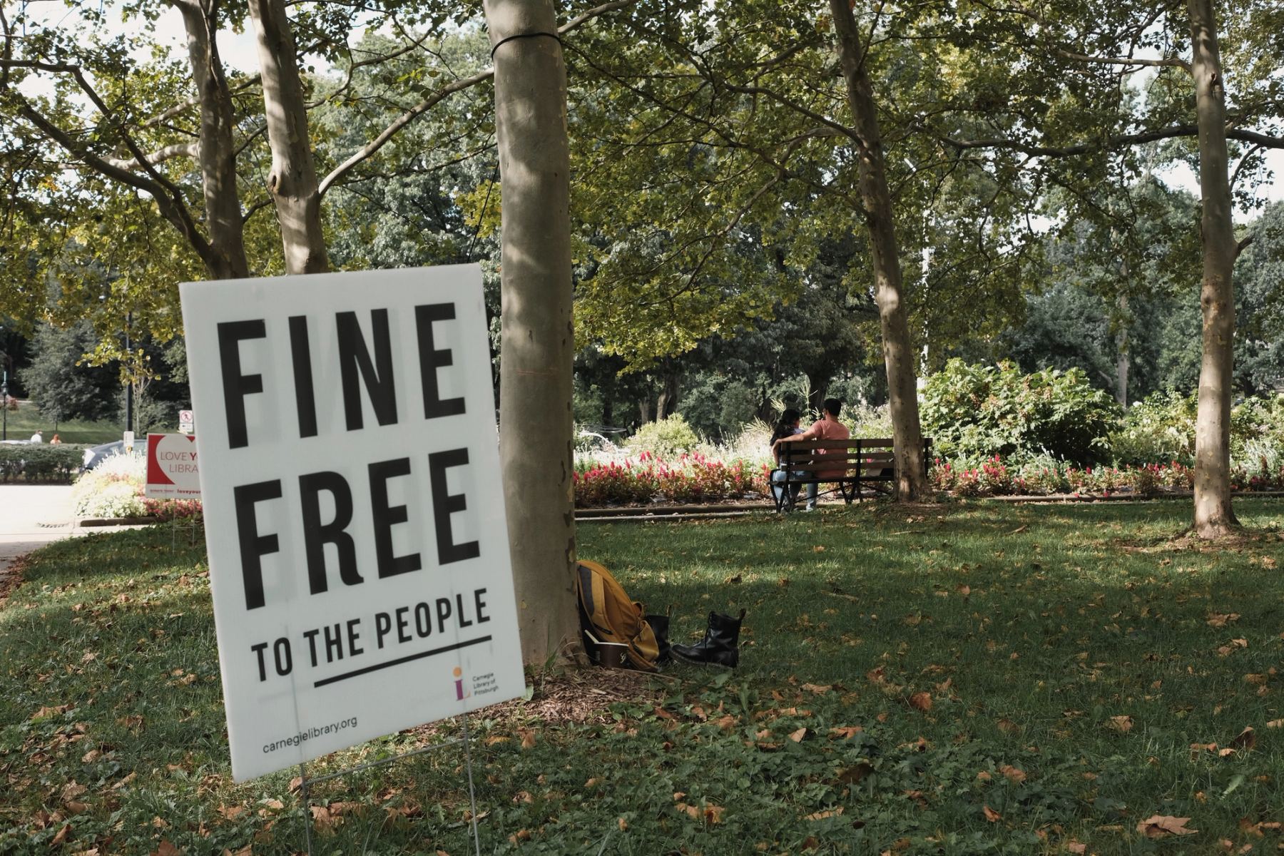 A sign and people sitting in the back