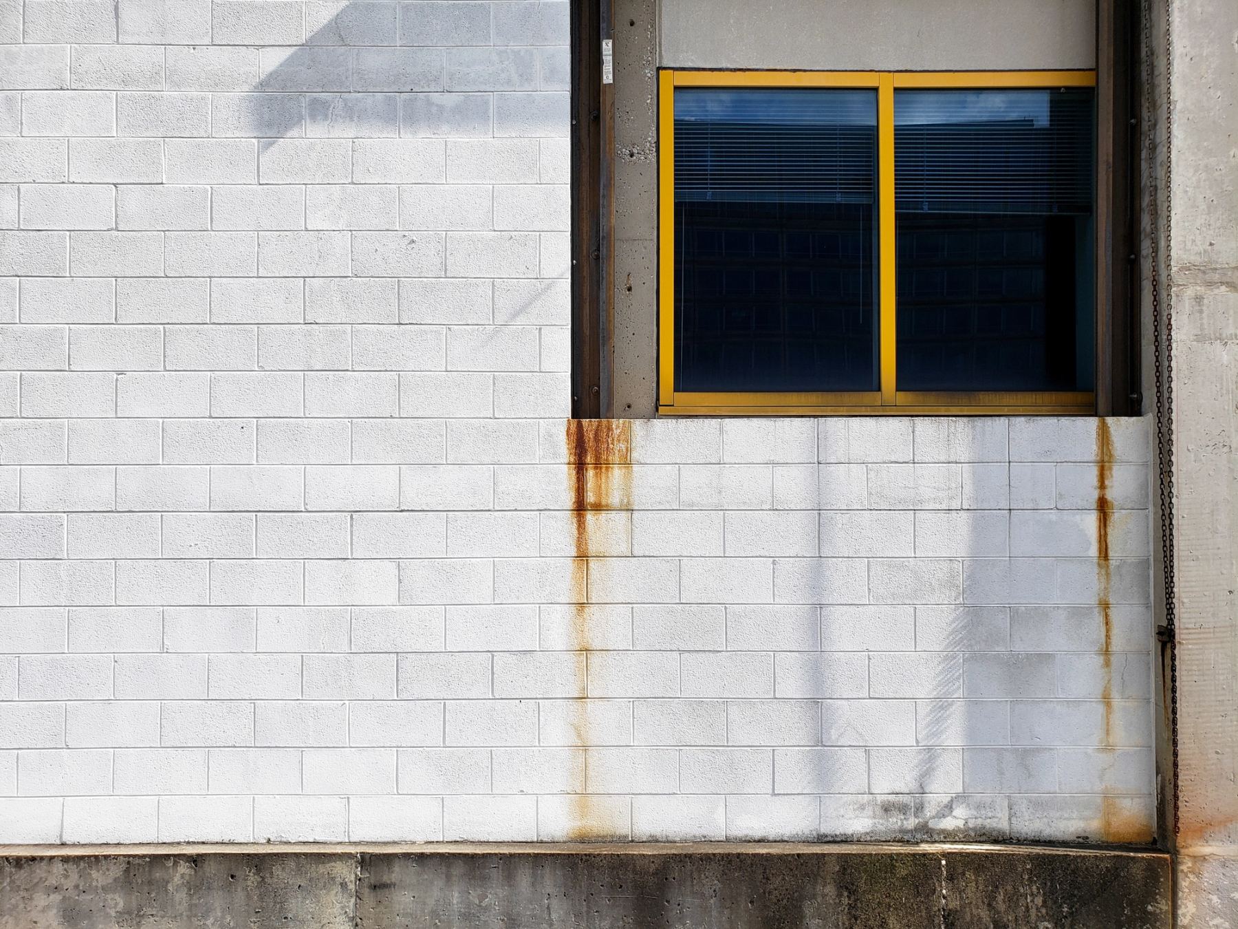 A window with yellow frame in a white wall