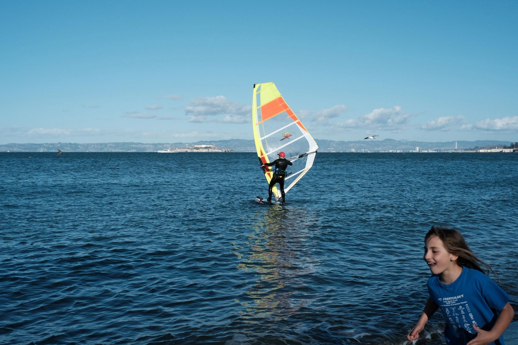 A person surfing and a girl running