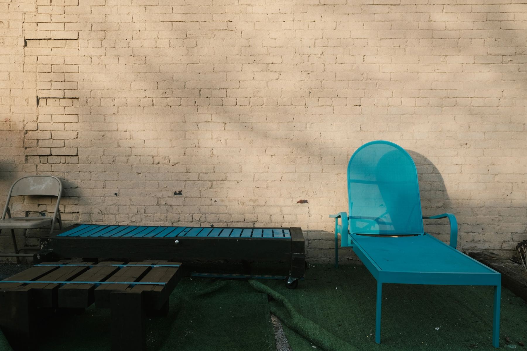 Blue chair and bench against light yellow wall