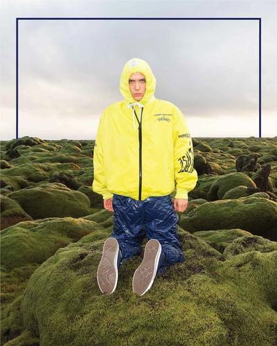 Man kneeling on the moss. Converse x P.A.M. (Perks and Mini) collab. 