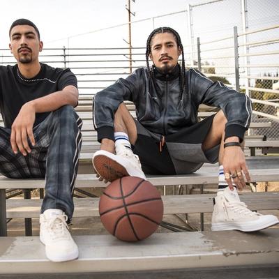 2 GUYS SITTING ON THE BLEACHERS W A BASKETBALL