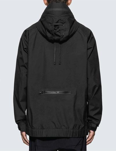 A man wearing a black gore-tex jacket standing with his back to the camera. Soloist x Converse collaboration.