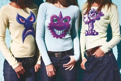 Three women standing modelling sweaters