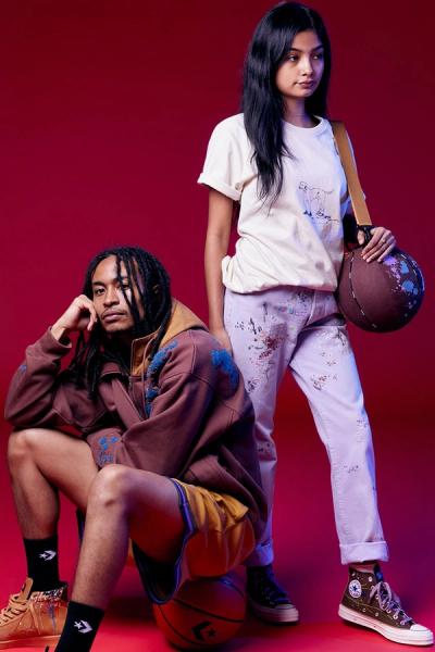 Man sitting on a basketball next to a woman holding a basketball