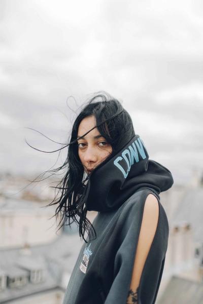 Dark haired woman looking into the camera. Converse X Faith Connexion, Koché, Feng Chen Wang collaboration