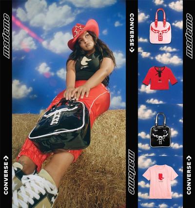 An images of model Paloma Elsesser (beautiful latinx woman) sitting on a bail of hay, wearing a pair of red 90s style nylon track pants with western details and a black tee with a graphic of brown cowboy boots while holding a black vinyl bowling style bag with white piping.. and a cowboy hat. Featured brands: Converse & MadeMe90s style red & white western tracksuit against a fake backdrop of a blue sky with white clouds. Featured brands: Converse & MadeMe. 