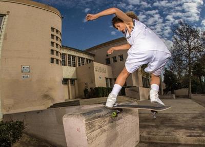 DUDE SKATEBOARDING IN A BASKETBALL UNIFORM