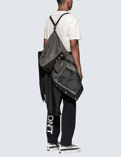 A man standing with his jacket falling off his back. Soloist x Converse collaboration.