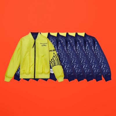 Horizontally repeated images of a yellow reversible bomber the interior of which is navy quilted. Converse x P.A.M. (Perks and Mini) collab.