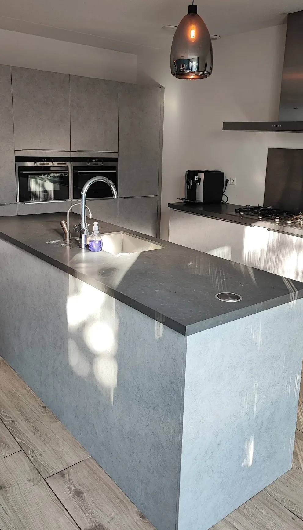 Hoge kastenwand in grijze betonlook