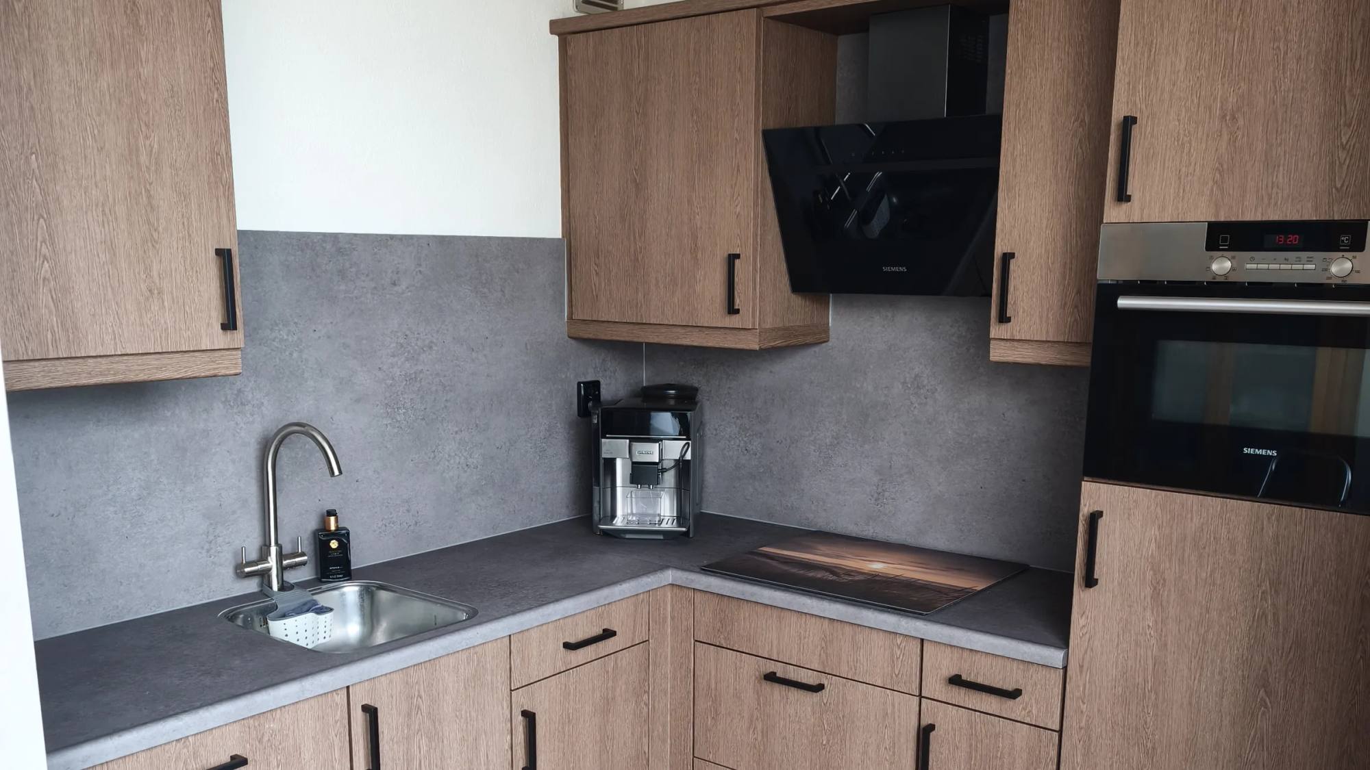 Keuken met nieuwe frontjes in Rich Wood en een achterwand in betonlook