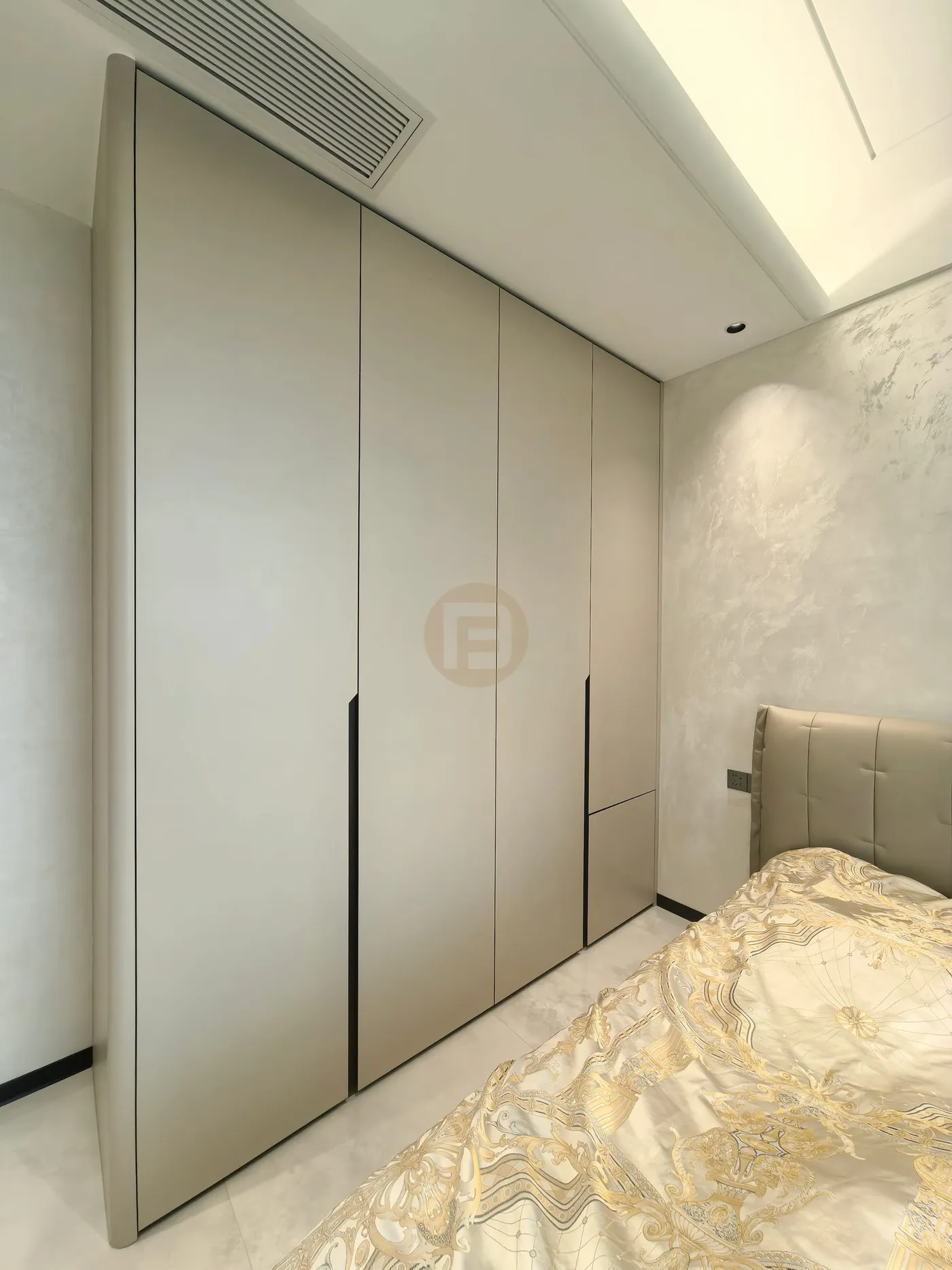 Bedroom wardrobe wall in champagne stainless steel with recessed black handle grooves