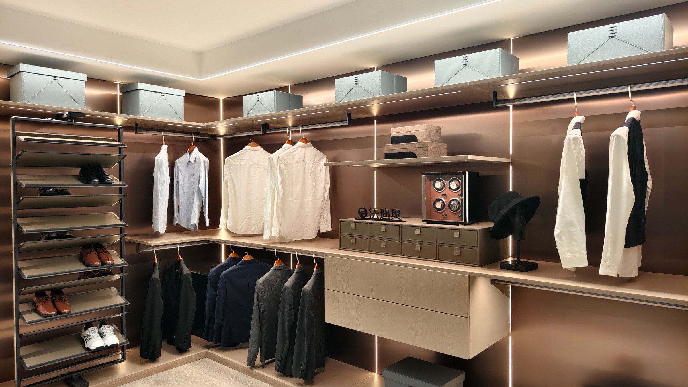 Walk-in wardrobe with illuminated rails, drawers and a central dressing island.