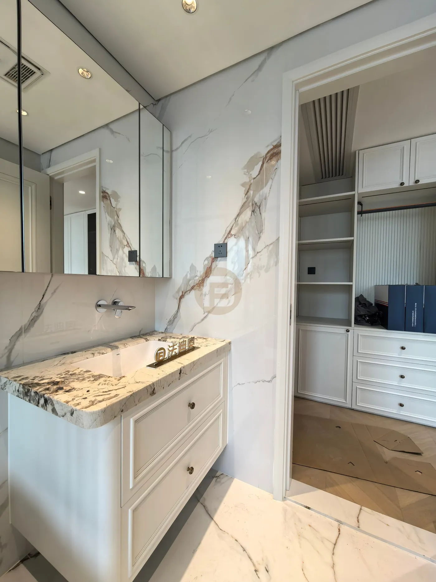 Stone-topped white stainless steel vanity with mirror cabinet, looking through to the fitted dressing area