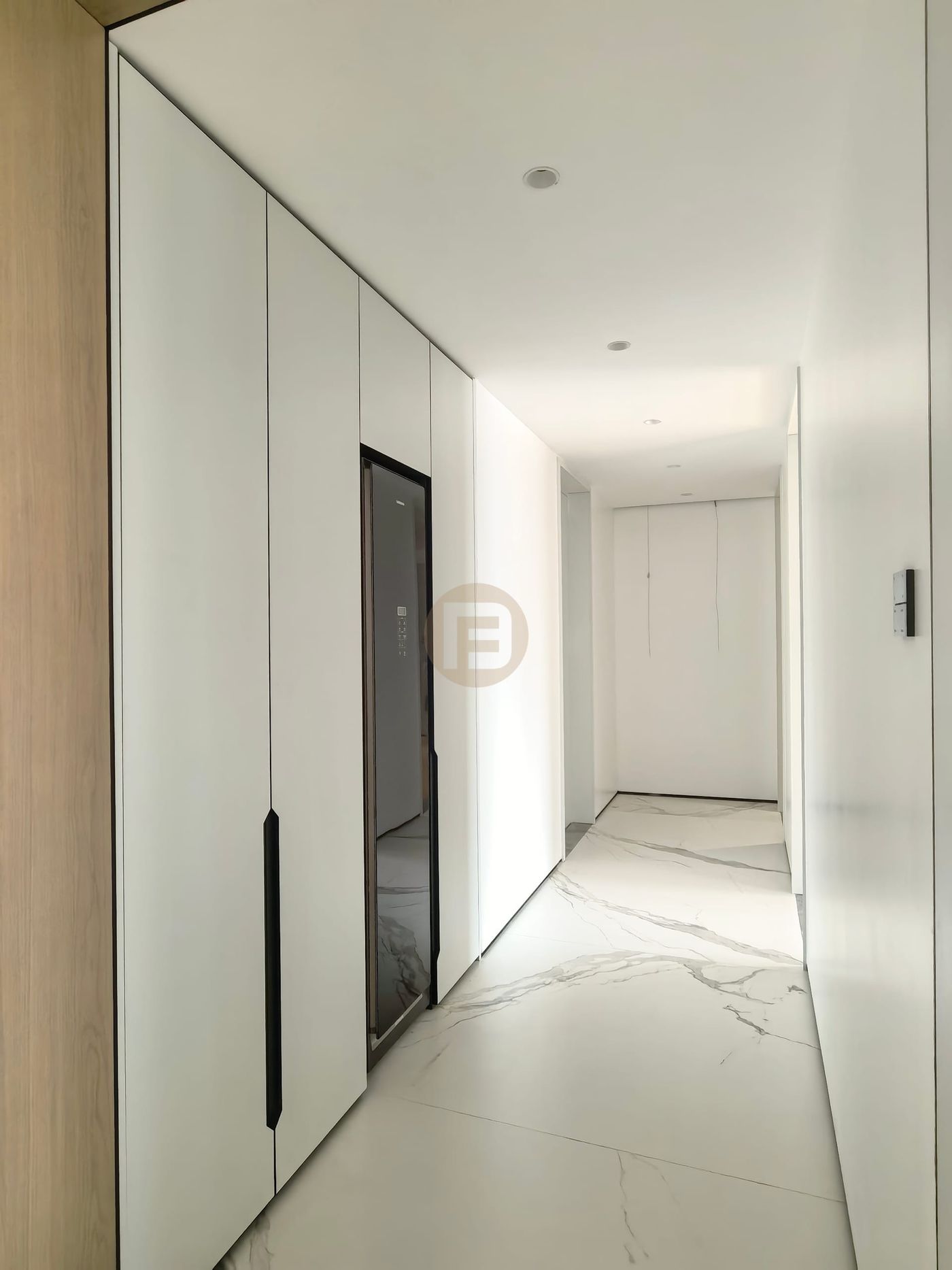 White hallway wardrobes with integrated full-length mirror over book-matched marble flooring