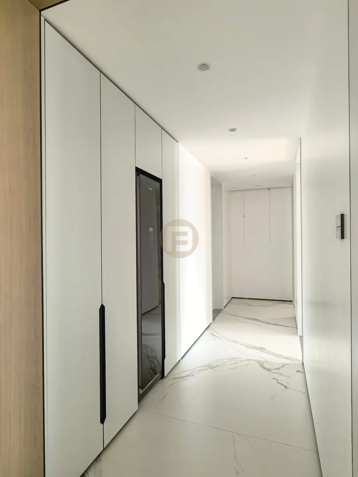 White hallway wardrobes with integrated full-length mirror over book-matched marble flooring