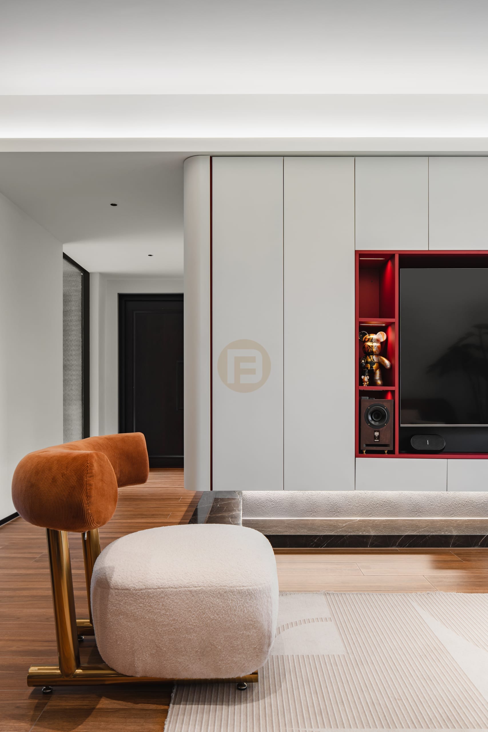 White stainless steel media wall with red-lacquered display niche and rounded corner panels
