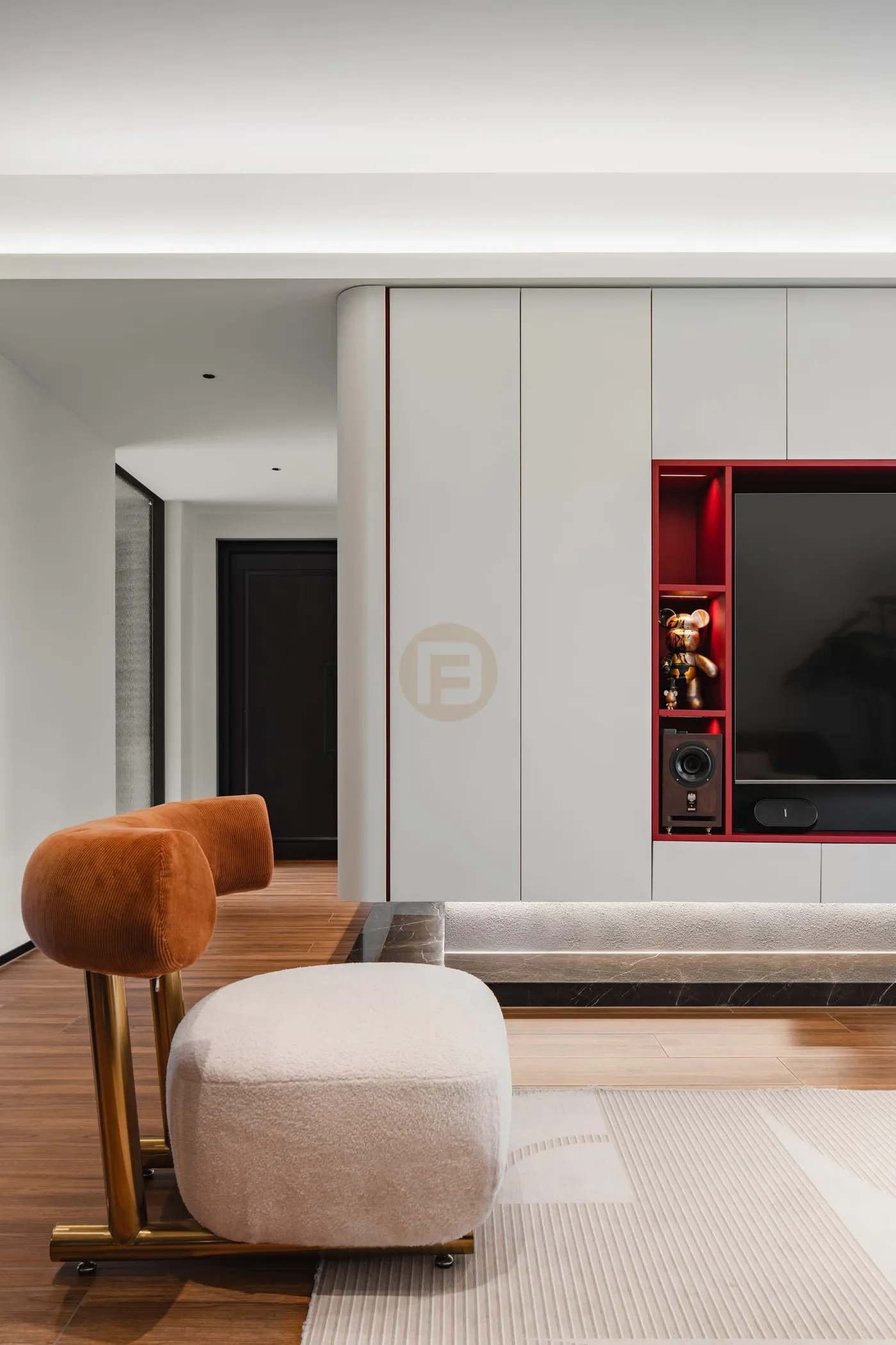 White stainless steel media wall with red-lacquered display niche and rounded corner panels