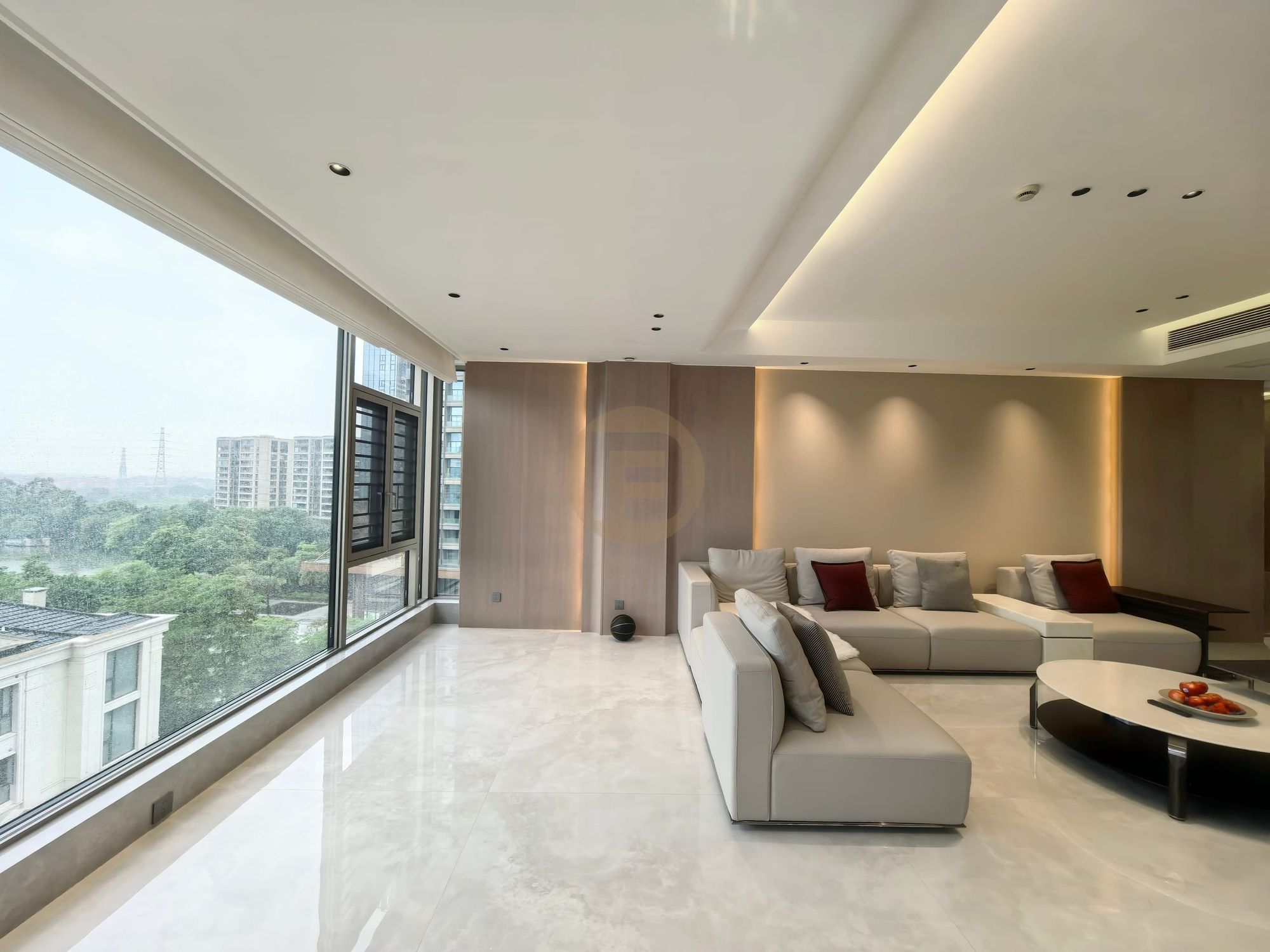 Open-plan living room with cream sofas, book-matched pale marble floor and a full wall of glazing