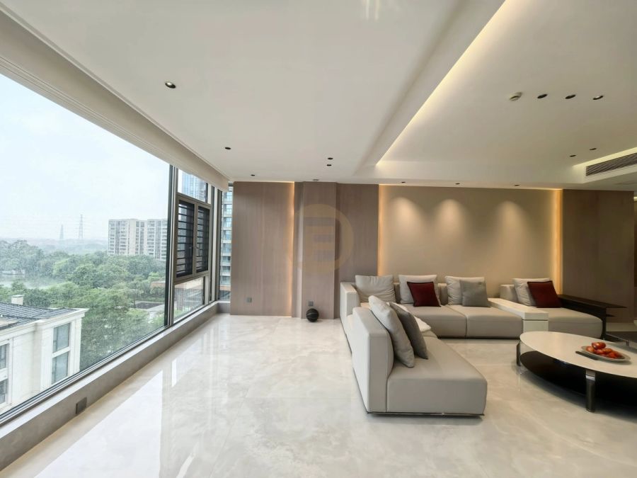Open-plan living room with cream sofas, book-matched pale marble floor and a full wall of glazing