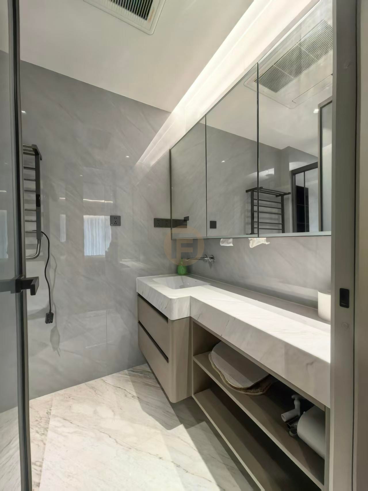 Marble-topped stainless steel bathroom vanity with mirrored cabinet and open towel shelf in a grey marble bathroom