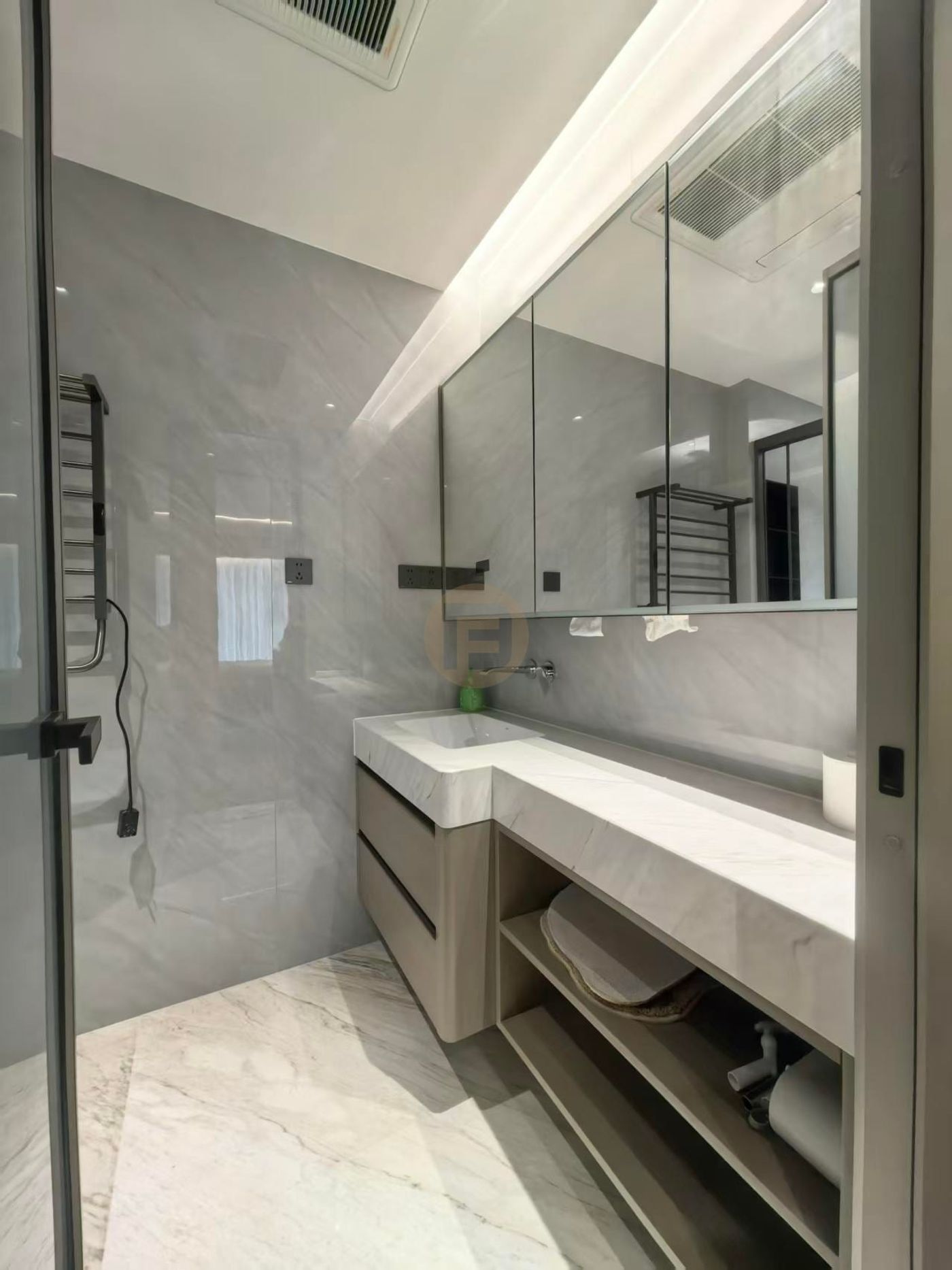 Marble-topped stainless steel bathroom vanity with mirrored cabinet and open towel shelf in a grey marble bathroom