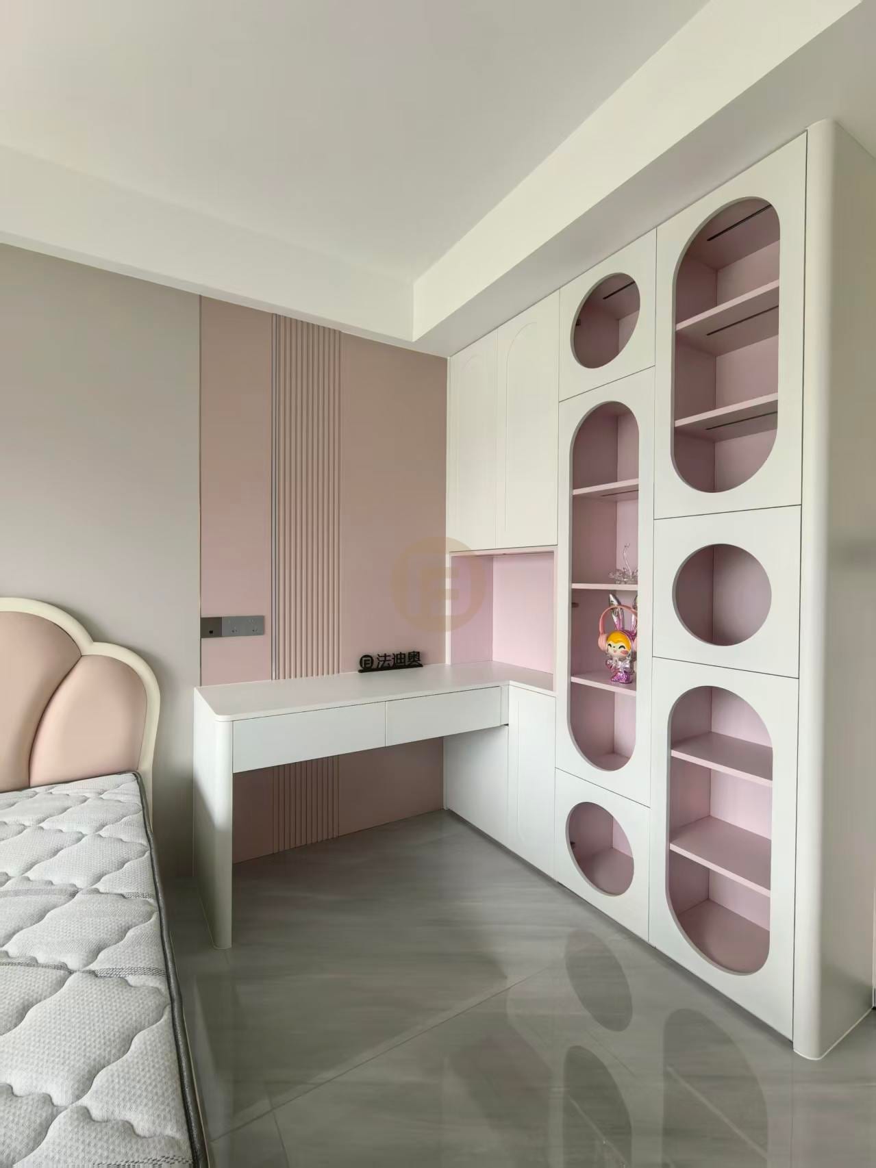 Children's room in powder pink and white with arched display niches and an integrated corner desk