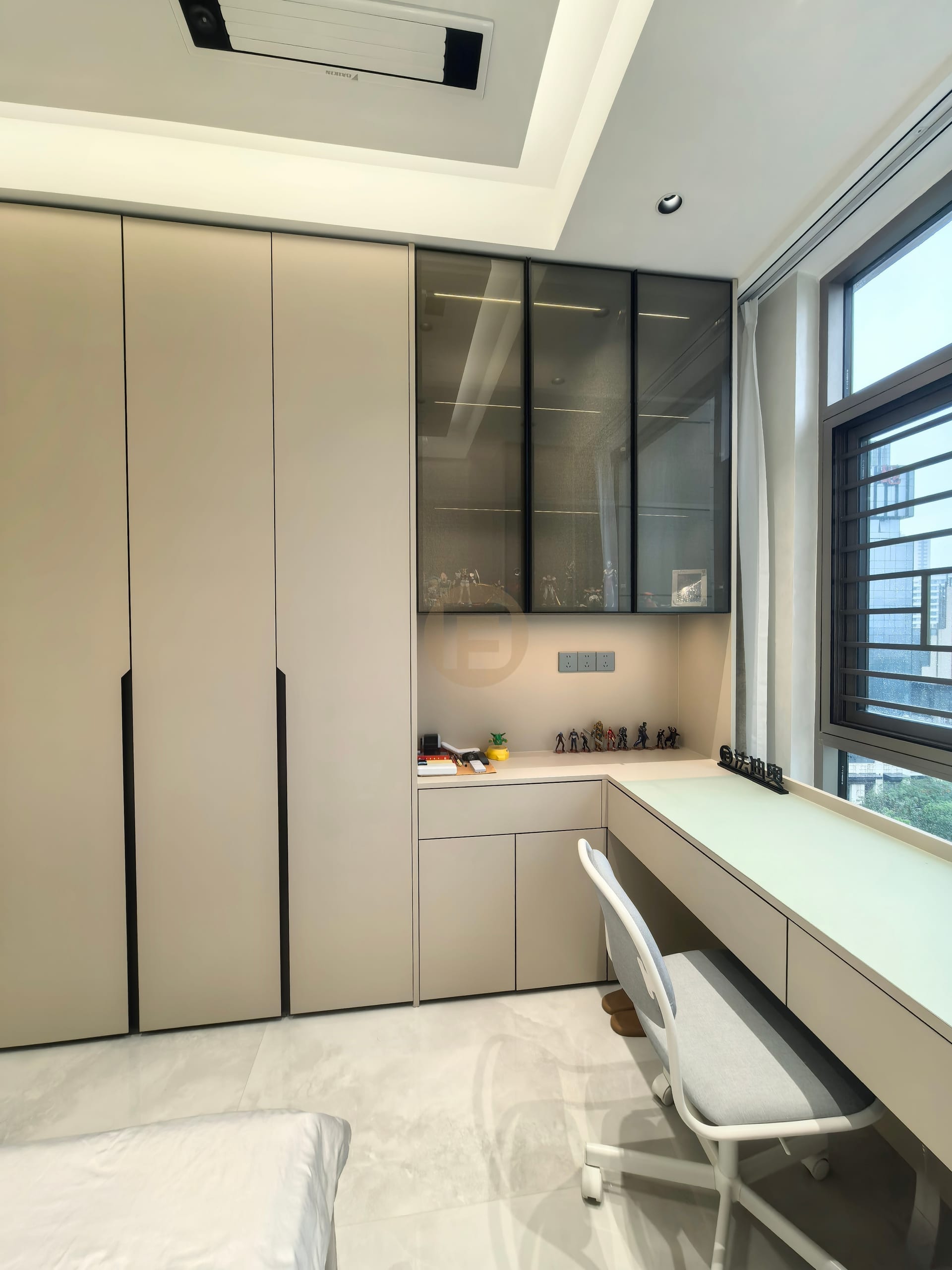 Built-in desk, glass-front display cabinet and wardrobe forming an L-shaped study corner