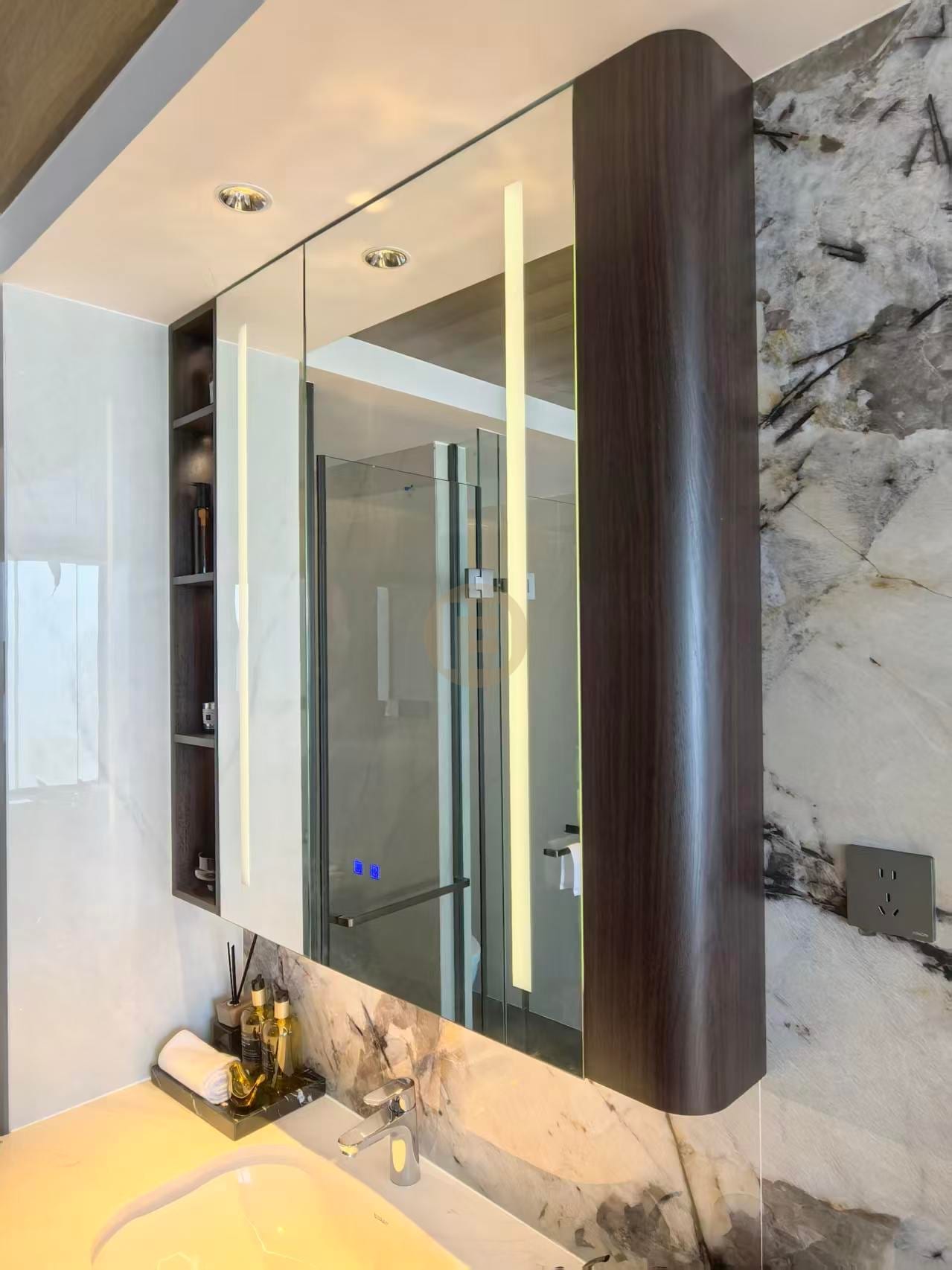 Curved mirror cabinet with integrated lighting and open shelving above the vanity