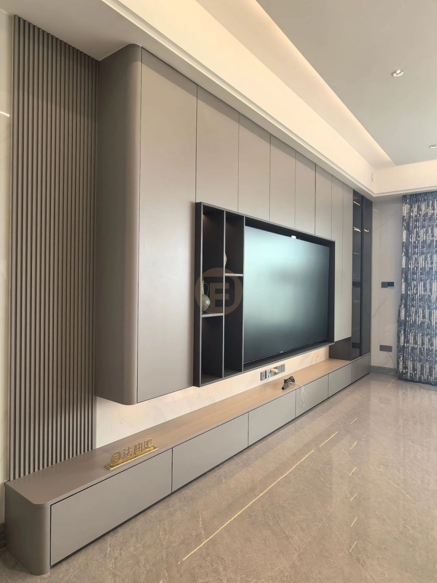 Living room media wall in taupe stainless steel cabinetry with fluted panelling and recessed TV niche