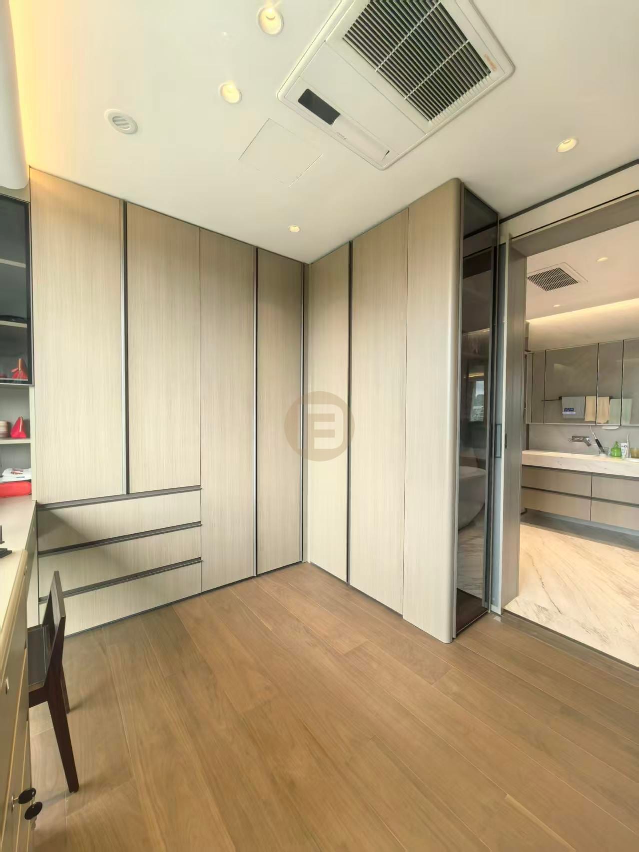 Pale greige stainless steel closet panels opening directly to a marble-lined bathroom