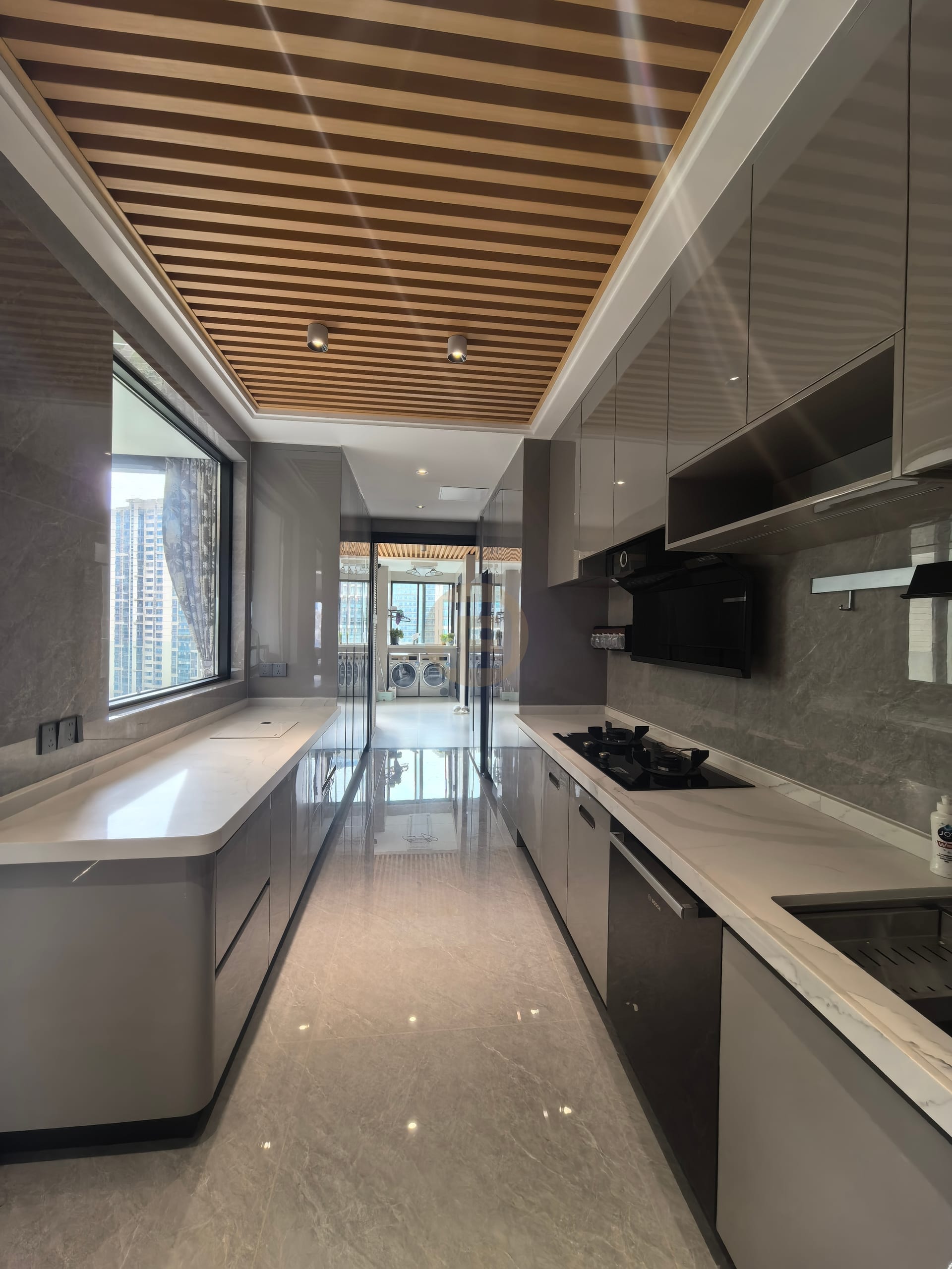 Galley kitchen with glossy grey stainless steel cabinetry under a timber-slat ceiling