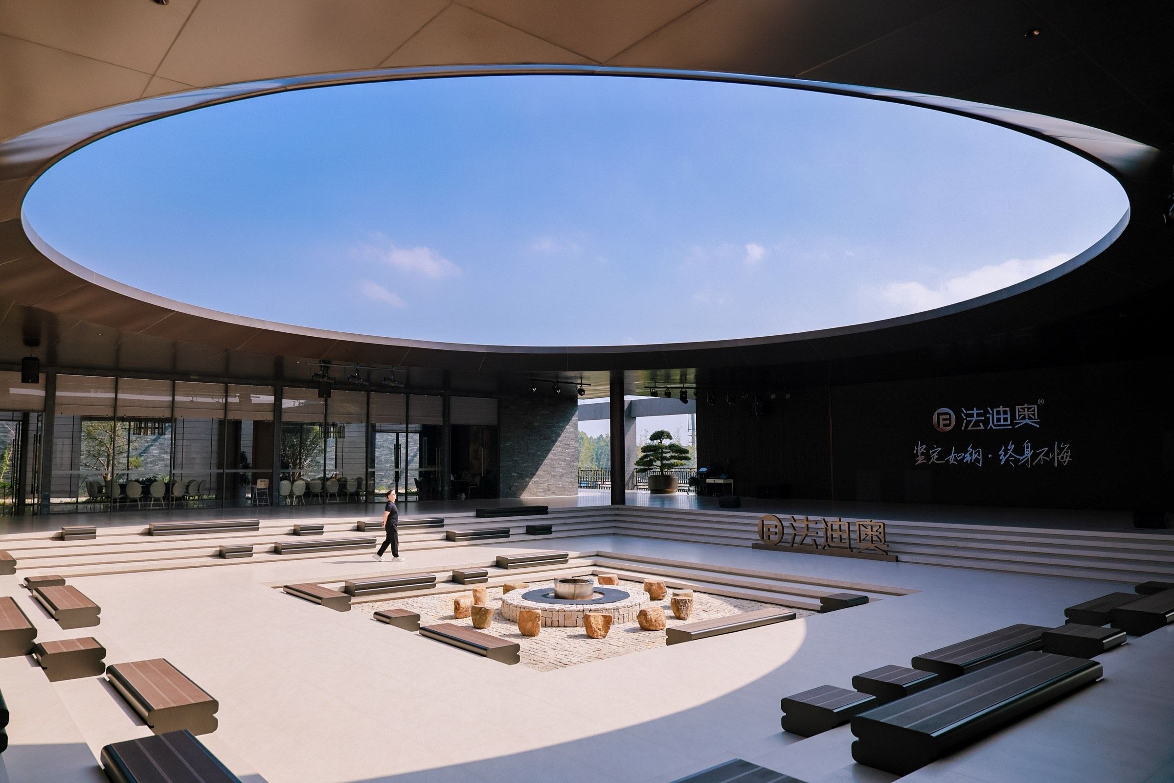 Open-air courtyard at Fadior's Foshan showroom with a circular skylight and lounge seating.