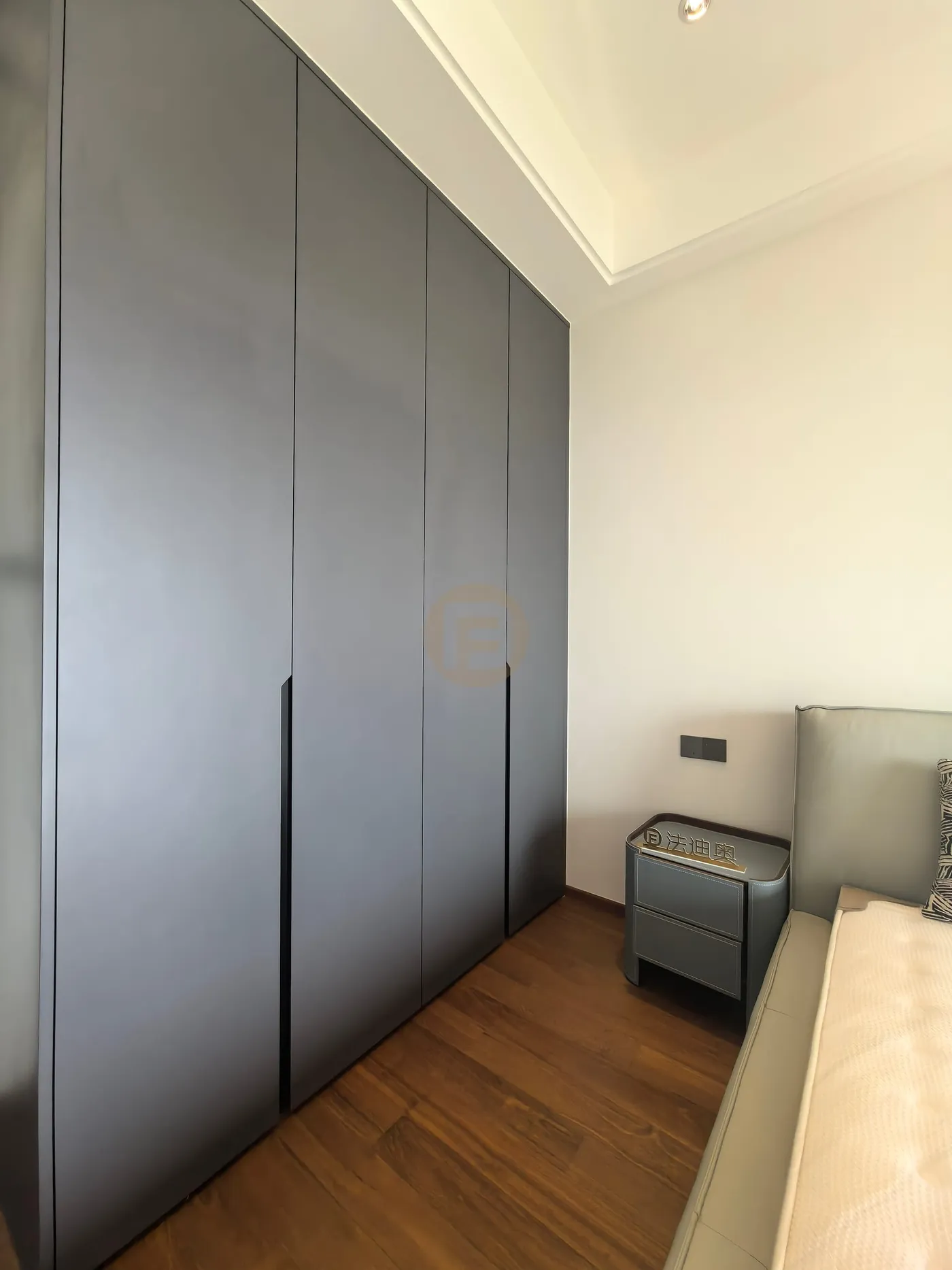 Charcoal floor-to-ceiling wardrobe wall with matching stainless steel nightstand in the bedroom