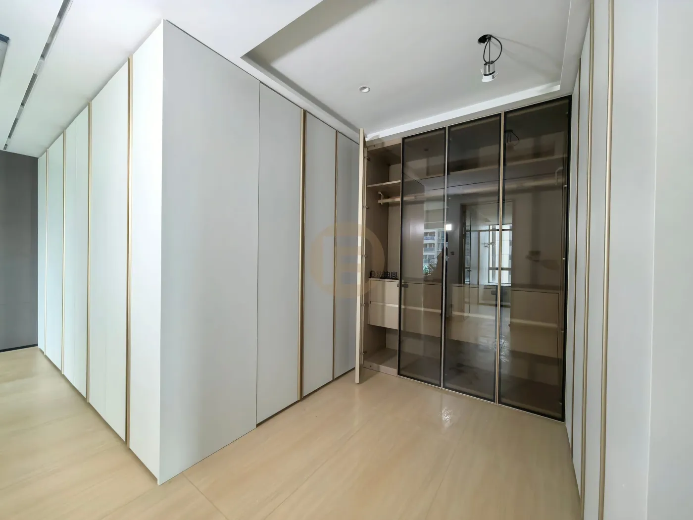 Walk-in dressing corridor with smoked bronze glass doors and pale grey lacquered stainless steel panels