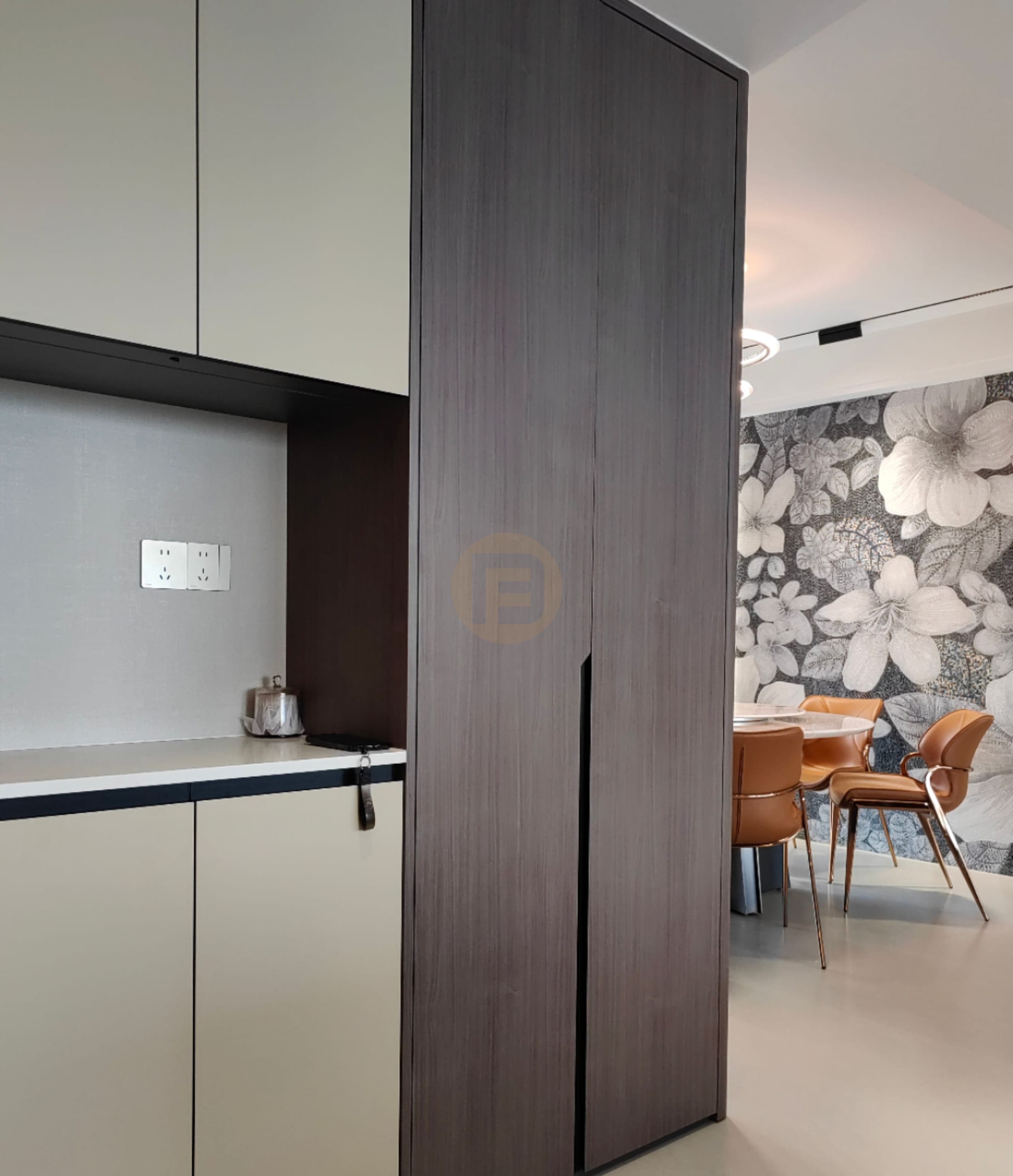 Champagne stainless steel service cabinets and a dark wood-grain column beside the floral-papered dining room
