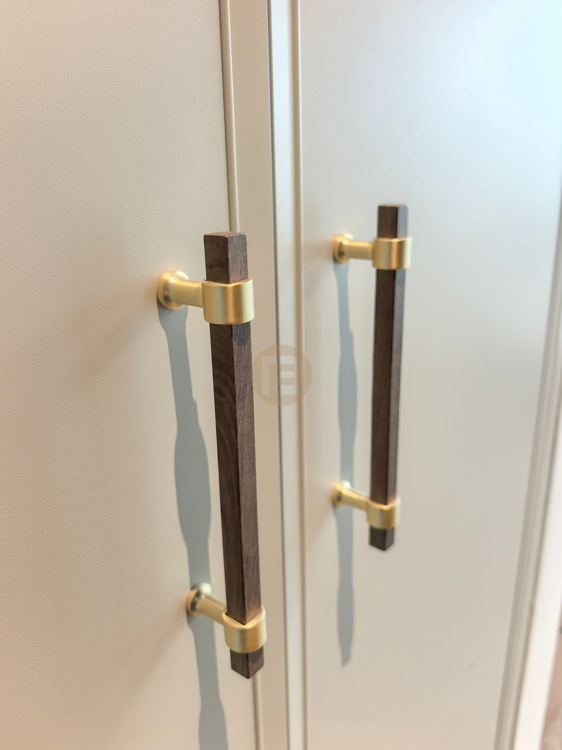 Turned walnut and brushed brass pulls on framed wardrobe doors