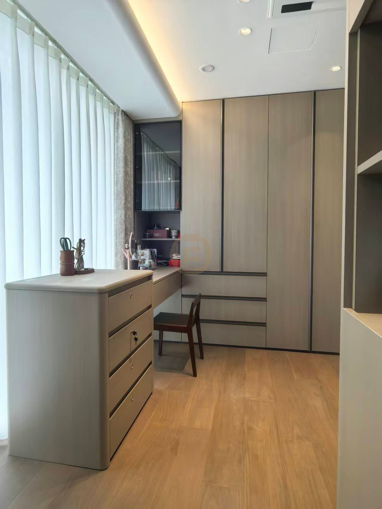 Dressing study with greige stainless steel wardrobes, built-in desk and chest of drawers by the window