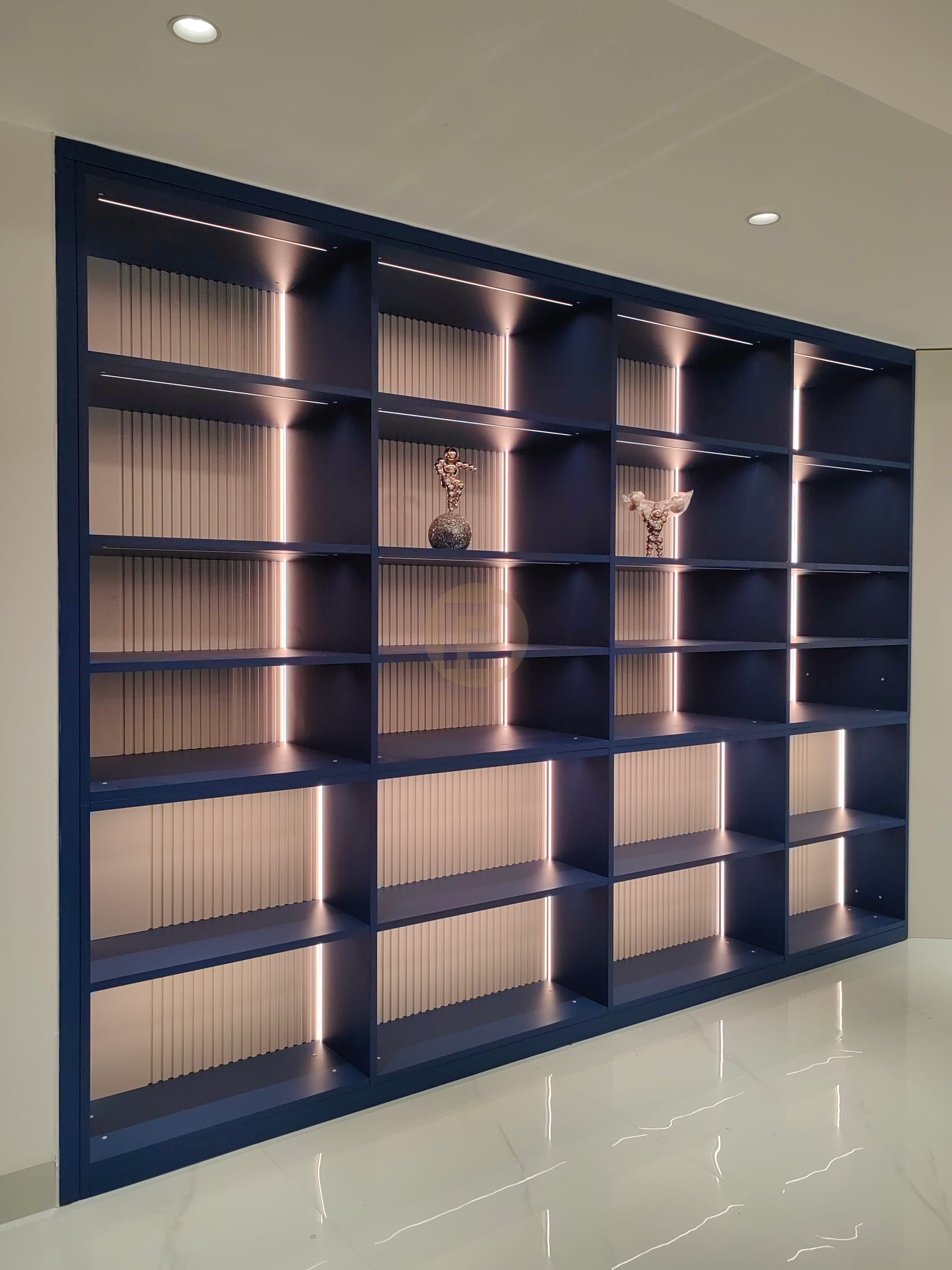 Navy blue display shelving with fluted back panels and integrated lighting