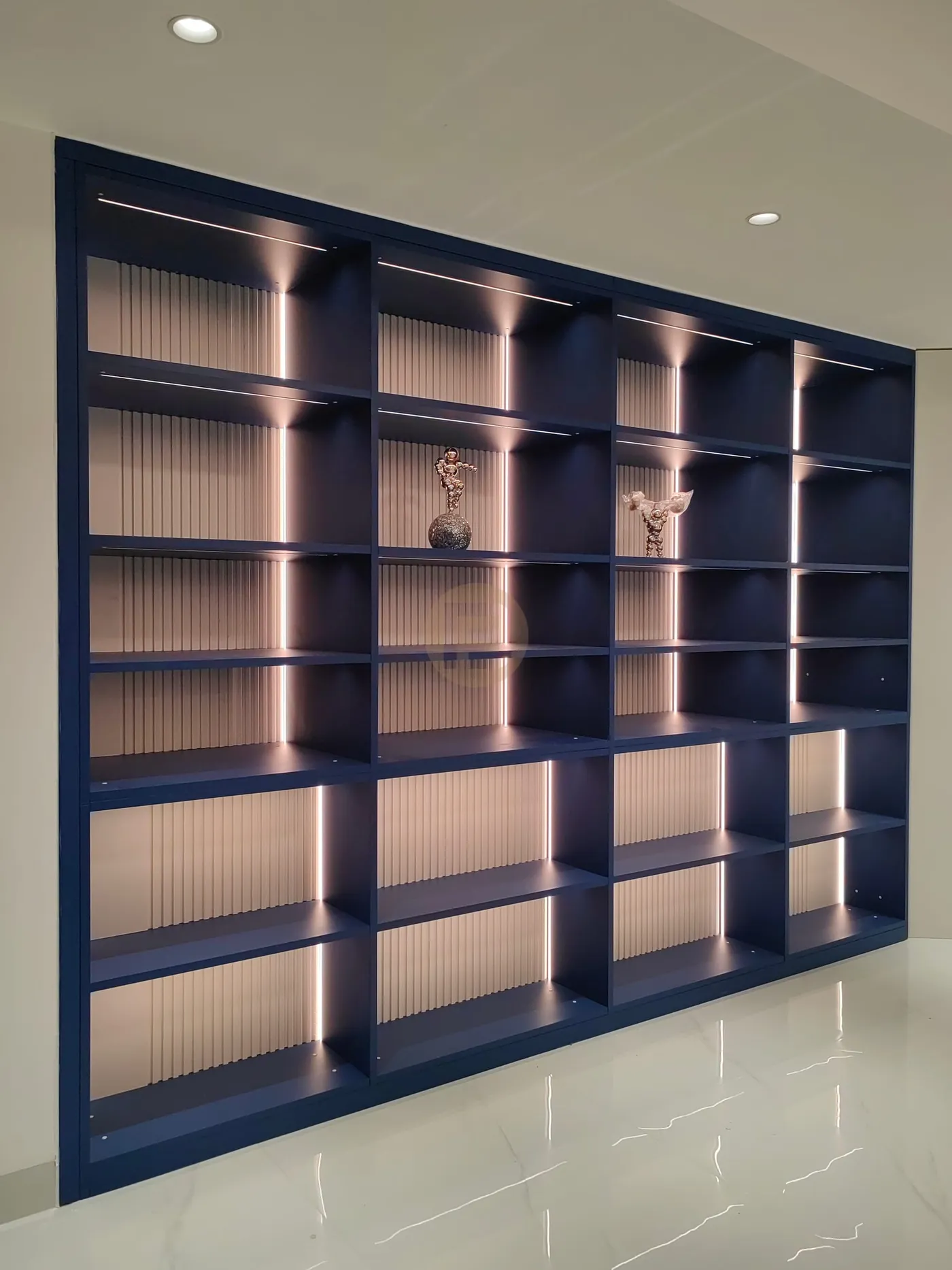 Navy blue display shelving with fluted back panels and integrated lighting